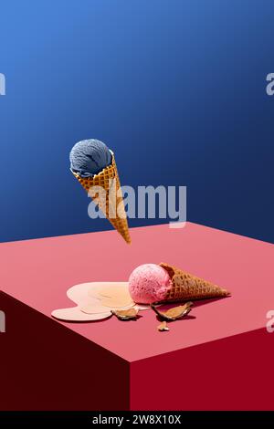 Schwebendes Heidelbeereis in Waffelkegel über Würfel mit liegendem schmelzendem rosa Eis vor blauem Hintergrund. Kreative Collage. Minimales Kunstwerk Stockfoto