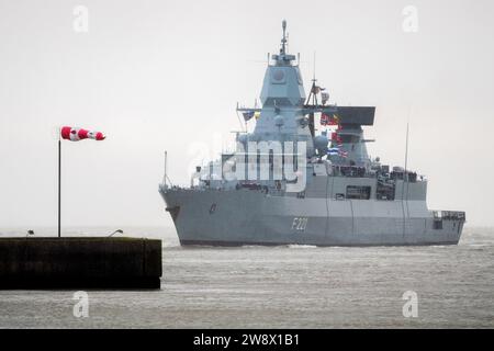 Wilhelmshaven, Deutschland. Dezember 2023. Die Fregatte „Hessen“ tritt bei starkem Wind am Marinestützpunkt in den Hafen ein. Mit rund 230 Soldaten und Frauen an Bord kehrte die Fregatte kurz vor Weihnachten in ihren Heimathafen zurück. In den letzten fünf Monaten hat das Schiff an drei großen Manövern und zahlreichen Übungen in der Nordsee, der Ostsee und im Nordatlantik teilgenommen. Quelle: Hauke-Christian Dittrich/dpa/Alamy Live News Stockfoto