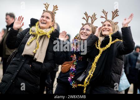 Wilhelmshaven, Deutschland. Dezember 2023. Stina (l-r), Lisa und Mareike winken den Besatzungsmitgliedern der Fregatte „Hessen“ zu, als das Schiff am Marinestützpunkt in den Hafen einfährt. Mit rund 230 Soldaten und Frauen an Bord kehrte die Fregatte kurz vor Weihnachten in ihren Heimathafen zurück. In den letzten fünf Monaten hatte das Schiff an drei großen Manövern und zahlreichen Übungen in der Nord-, Ostsee- und Nordatlantik teilgenommen. Quelle: Hauke-Christian Dittrich/dpa/Alamy Live News Stockfoto