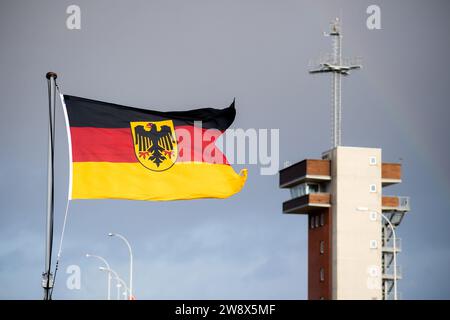 Wilhelmshaven, Deutschland. Dezember 2023. Eine Flagge der Bundesrepublik Deutschland fliegt im Wind an Bord der Fregatte „Hessen“, nachdem sie am Marinestützpunkt angekommen ist. Mit rund 230 Soldaten und Frauen an Bord kehrte die Fregatte kurz vor Weihnachten in ihren Heimathafen zurück. In den letzten fünf Monaten hatte das Schiff an drei großen Manövern und zahlreichen Übungen in der Nord-, Ostsee- und Nordatlantik teilgenommen. Quelle: Hauke-Christian Dittrich/dpa/Alamy Live News Stockfoto