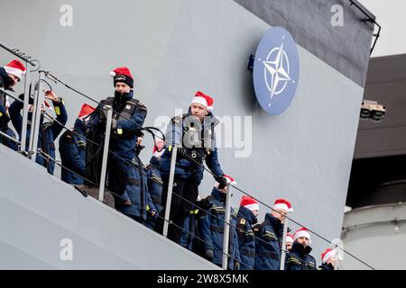 Wilhelmshaven, Deutschland. Dezember 2023. Besatzungsmitglieder mit Weihnachtsmützen stehen an Bord der Fregatte „Hessen“, während das Schiff in den Hafen am Marinestützpunkt einfährt. Mit rund 230 Soldaten und Frauen an Bord kehrte die Fregatte kurz vor Weihnachten in ihren Heimathafen zurück. In den letzten fünf Monaten hatte das Schiff an drei großen Manövern und zahlreichen Übungen in der Nord-, Ostsee- und Nordatlantik teilgenommen. Quelle: Hauke-Christian Dittrich/dpa/Alamy Live News Stockfoto