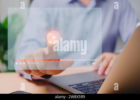 Man streamt Live-Inhalte auf einem virtuellen Bildschirm über ein Notebook für Online-Konzerte, Shows, Tutorials und Multimedia-Wiedergabe. Stockfoto