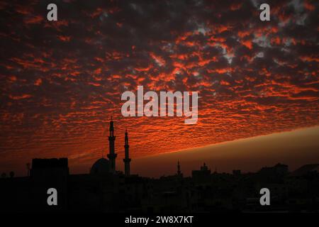 Rafah, Gaza. Dezember 2023. Der Himmel ist rot beleuchtet bei Sonnenuntergang hinter den Minaretten der Moschee in Rafah im südlichen Gazastreifen, am Freitag, den 22. Dezember 2023. Foto: Ismael Mohamad/UPI Credit: UPI/Alamy Live News Stockfoto