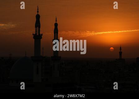 Rafah, Gaza. Dezember 2023. Der Himmel ist rot beleuchtet bei Sonnenuntergang hinter den Minaretten der Moschee in Rafah im südlichen Gazastreifen, am Freitag, den 22. Dezember 2023. Foto: Ismael Mohamad/UPI Credit: UPI/Alamy Live News Stockfoto