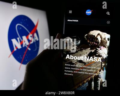 Person, die ein Mobiltelefon hält, mit Webseite der US National Aeronautics and Space Administration (NASA) mit Logo. Konzentrieren Sie sich auf die Mitte des Telefondisplays. Stockfoto