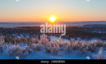 (231222) -- HULUN BUIR, 22. Dezember 2023 (Xinhua) -- dieses Luftfoto zeigt einen Sonnenuntergang auf Erdendalais Weide in Hulun Buir, nordchinesischer autonomer Region Innere Mongolei, 16. Dezember 2023. Der Winter bedeutet normalerweise Herausforderungen für Hirten, die auf dem Grasland leben. Starke Kälte und Schnee beeinflussen immer ihr tägliches Leben. Aber für Erdendalai, einen Hirten, der in Hulun Buir lebt, ist der Winter immer noch eine arbeitsreiche Jahreszeit. Neben der Betreuung von mehr als 200 Rindern, Schafen und Pferden, die er besitzt, genießt Erdendalai auch eine wichtige Aktivität des Pferderennens. Pferde waren schon immer ein zuverlässiges Mittel zur Übertragung Stockfoto