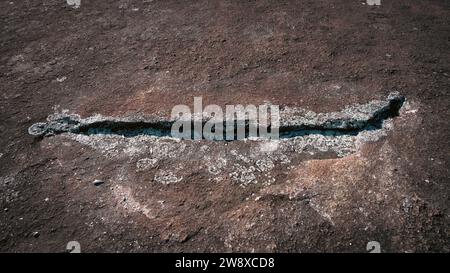 Riss umgeben von Flechten in Felsenwand, die einem menschlichen Lächeln ähnelt Stockfoto