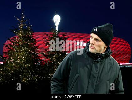 München, Deutschland 22. Dezember 2023: Fussball, Herren, Bundesliga, Saison 2023/2024, FC Bayern München, Allianz Arena! Achtung Fotomontage! Hier im Bild Thomas Tuchel, Trainer (FC Bayern München) Kopf, Oberkörper mit Weihnachtsbäumen, Christbäumen, Tannenbäumen vor der Allianz Arena, Weihnachtswünsche, Spielerwünsche, Geschenke, Symbolbild, Überraschung, Weihnachtsgeschenk Stockfoto