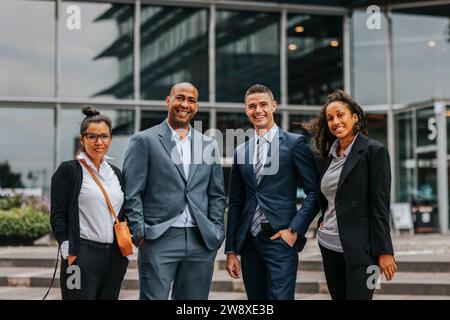 Porträt lächelnder, multirassischer Geschäftsleute, die vor dem Gebäude stehen Stockfoto