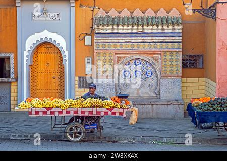 Marokkanischer Straßenhändler, der Bananen und andere Früchte in der Stadt Beni Mellal, Region Béni Mellal-Khénifra, Marokko, verkauft Stockfoto