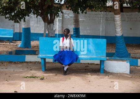 Schulmädchen in Uniform, sitzt in einem Park in Banjul, Gambia Stockfoto