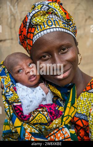 Mutter in traditioneller Kleidung und Baby in Serekunda, Gambia Stockfoto