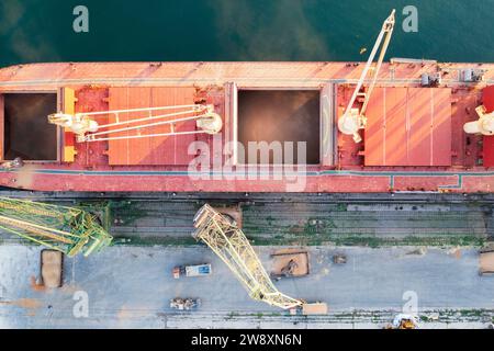 Draufsicht von einer Drohne eines großen Schiffes, das Getreide für den Export lädt. Wassertransport Stockfoto