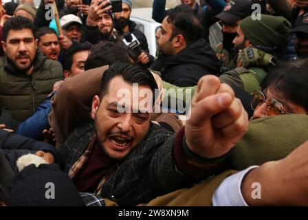 Srinagar Kaschmir, Indien. Dezember 2023. Mitglieder des Jammu und des Kaschmir Pradesh Congress Committee (JKPCC) schreien Slogans, während die Polizei versucht, sie während eines Protestes in Srinagar aufzuhalten. Die Proteste wurden gegen die Massenaussetzung von Oppositionsabgeordneten abgehalten, die eine Klarstellung über den jüngsten Sicherheitsverfall innerhalb des Parlaments forderten. Der Protest wurde vom All India Congress Committee über die "undemokratische Entscheidung" organisiert, die Oppositionsgesetzgeber aus dem Parlament zu suspendieren. Bis jetzt wurden 143 Abgeordnete in der Wintersitzung in Lok Sabha und Rajya Sabha suspendiert, die höchsten im indischen Parlament Stockfoto