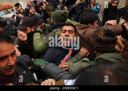 Srinagar Kaschmir, Indien. Dezember 2023. Mitglieder des Jammu und des Kaschmir Pradesh Congress Committee (JKPCC) schreien Slogans, während die Polizei versucht, sie während eines Protestes in Srinagar aufzuhalten. Die Proteste wurden gegen die Massenaussetzung von Oppositionsabgeordneten abgehalten, die eine Klarstellung über den jüngsten Sicherheitsverfall innerhalb des Parlaments forderten. Der Protest wurde vom All India Congress Committee über die "undemokratische Entscheidung" organisiert, die Oppositionsgesetzgeber aus dem Parlament zu suspendieren. Bis jetzt wurden 143 Abgeordnete in der Wintersitzung in Lok Sabha und Rajya Sabha suspendiert, die höchsten im indischen Parlament Stockfoto