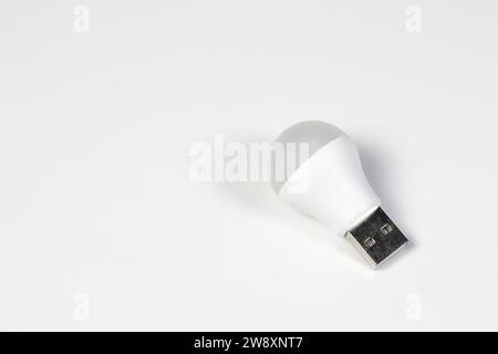 Weiße LED-Glühlampe mit USB-Anschluss Typ A zur Energieeinsparung isoliert auf weißem Hintergrund. Stockfoto