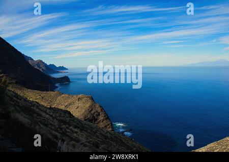 Panoramablick auf die schroffen Klippen an der Westküste von Gran Canaria mit der Silhouette von Teneriffa und dem Vulkan Mount Teide am Horizont, Kanarische Insel Stockfoto