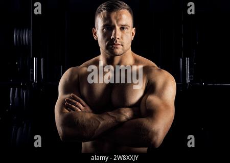 Der Gewichtheber posiert vor der Kamera mit überkreuzten Armen über der Brust. Vorderansicht Stockfoto