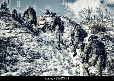 Eine Gruppe von Spezialkräften steigt in die Berge, um eine günstige Position zum Schutz des Ziels einzunehmen. Gemischte Medien Stockfoto