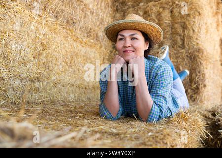 Frau posiert auf dem Bauernhof im Heulager Stockfoto