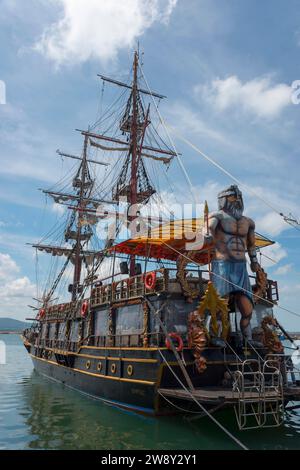 Ein großes Segelschiff mit vielen Masten und einer Piratenstatue an Bord liegt im Meer, ein Vergnügungssegelboot in Form eines Piratenschiffs Stockfoto
