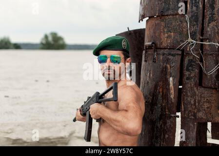 Ein Mann mit einer Waffe in einem militärischen Konflikt Stockfoto