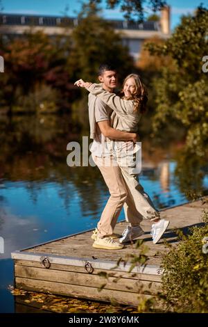 Riverside Romance: Liebesgeschichte des jungen Paares. Ein glückliches Paar in lässiger Kleidung reist zusammen, wandert und hat Spaß im Herbstwald auf einem Stockfoto
