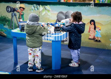 Mostoles, Madrid, Spanien. Dezember 2023. Zwei Kinder spielen mit Playmobil-Figuren in der Ausstellung Giant Playmobil Krippe auf der Plaza de las Constelaciones in Mostoles, Spanien. (Kreditbild: © Angel Perez/ZUMA Press Wire) NUR REDAKTIONELLE VERWENDUNG! Nicht für kommerzielle ZWECKE! Quelle: ZUMA Press, Inc./Alamy Live News Stockfoto