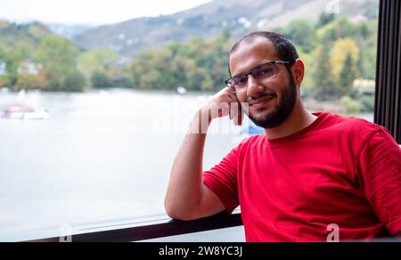 Junger arabischer Mann, der sich während seines Urlaubs entspannt fühlte und seine Zeit genoss Stockfoto