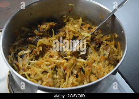 Zuvor zubereitete Gemüsefüllung in einem hausgemachten Kuchen. Es besteht aus gehacktem Kohl, Zwiebeln und Steinpilzstücken. Stockfoto