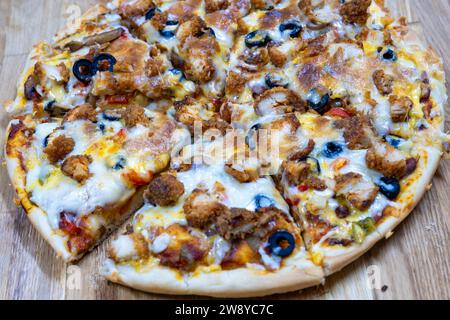 Hausgemachte Pizza auf Holzbrett mit Zingger und Oliven-Belag Stockfoto