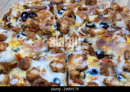 Hausgemachte Pizza auf Holzbrett mit Zingger und Oliven-Belag Stockfoto