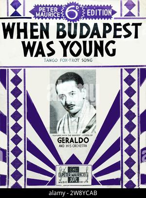 Vintage Notencover When Budapest Was Young, ein Tangofox-Trab-Song von Peter Maurice Music Co. Ltd., London, ca. 1930s. Diese Ausgabe zeigt den britischen Tanzkapellmeister Geraldo und sein Orchester, das für ihren großen Erfolg in der Zwischenkriegszeit bekannt ist. Das auffällige geometrische Art déco-Design mit violetten Akzenten spiegelt den visuellen Stil des Musikverlags der 1930er Jahre wider. Das Stück hebt sowohl den kontinentalen musikalischen Einfluss als auch die Prominenz der Londoner Tanzbandkultur hervor. Stockfoto