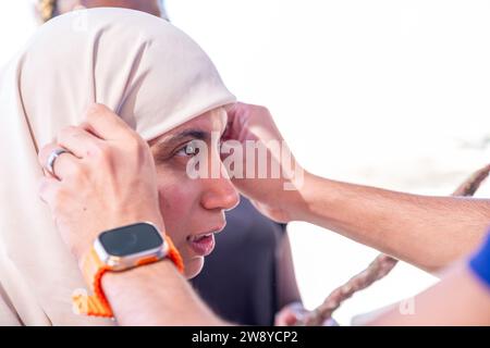 muslimische Frau passt ihren Hijab mit Hilfe einer anderen Person an Stockfoto