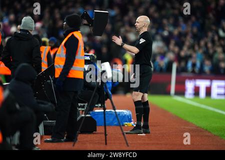 Schiedsrichter Anthony Taylor überprüft den VAR-Bildschirm auf dem Feld, bevor er Aston Villas erstes Tor des Spiels für ein Foul gegen Sheffield United Torhüter Wes Foderingham während des Premier League-Spiels in Villa Park, Birmingham, überwindet. Bilddatum: Freitag, 22. Dezember 2023. Stockfoto