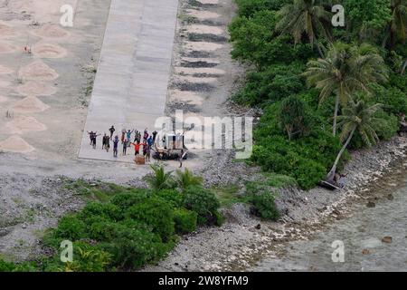 Luftwaffenstützpunkt Andersen, Guam. Dezember 2023. Die Inselbewohner holen humanitäre Hilfspakete ab, nachdem sie fallen und jubeln, als ein C-130J Super Hercules der 36th Expeditionary Airlift Squadron im Dezember in den Föderierten Staaten von Mikronesien vorbeigeht. 8., 2023, während des Betriebs Weihnachtsfeiertag 2023 (OCD 23). Die 1952 gegründete OCD hat sich zur am längsten laufenden humanitären Hilfe- und Katastrophenhilfe des Verteidigungsministeriums entwickelt, die über 20.000 Inselbewohnern auf 58 Inseln in den Föderierten Staaten von Mikronesien und der Republik Palau zugute kommt Stockfoto