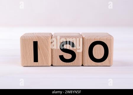 Internationale Organisation für Normung. Holzwürfel mit der Abkürzung ISO auf weißem Tisch, Großansicht Stockfoto