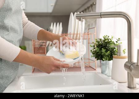 Frau wäscht Schüssel am Waschbecken in der Küche, Nahaufnahme Stockfoto