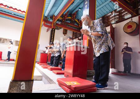 Bandung, Indonesien - 8. Januar 2022 : buddhistische Menschen beten zusammen mit den Mönchen, während sie die Opfergabe vor dem Altar im Inneren des Buddha geben Stockfoto