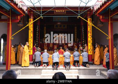 Bandung, Indonesien - 8. Januar 2022 : buddhistische Menschen beten zusammen mit den Mönchen, während sie die Opfergabe vor dem Altar im Inneren des Buddha geben Stockfoto