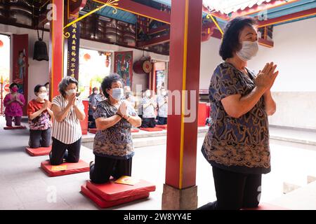 Bandung, Indonesien - 8. Januar 2022 : buddhistische Menschen beten zusammen mit den Mönchen, während sie die Opfergabe vor dem Altar im Inneren des Buddha geben Stockfoto