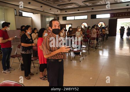 Bandung, Indonesien - 8. Januar 2022 : buddhistische Menschen beten zusammen mit den Mönchen, während sie die Opfergabe vor dem Altar im Inneren des Buddha geben Stockfoto