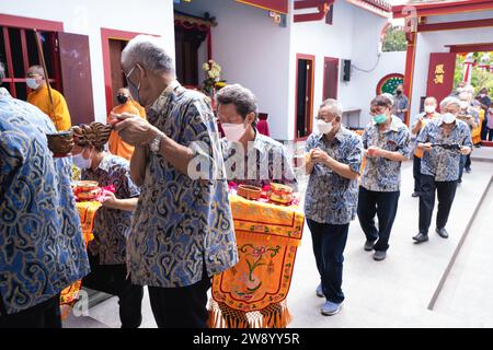 Bandung, Indonesien - 8. Januar 2022 : buddhistische Menschen beten zusammen mit den Mönchen, während sie die Opfergabe vor dem Altar im Inneren des Buddha geben Stockfoto