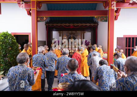 Bandung, Indonesien - 8. Januar 2022 : buddhistische Menschen beten zusammen mit den Mönchen, während sie die Opfergabe vor dem Altar im Inneren des Buddha geben Stockfoto