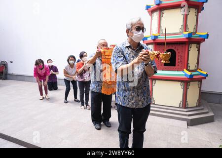 Bandung, Indonesien - 8. Januar 2022 : buddhistische Menschen beten zusammen mit den Mönchen, während sie die Opfergabe vor dem Altar im Inneren des Buddha geben Stockfoto