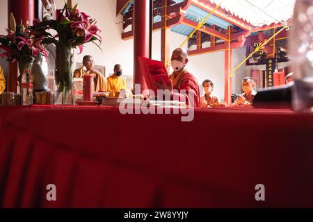 Bandung, Indonesien - 8. Januar 2022: Der alte Mann bringt die Opfer auf den Altar, während er mit den Mönchen im Buddha-Tempel betet Stockfoto