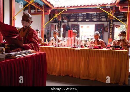 Bandung, Indonesien - 8. Januar 2022: Der alte Mann bringt die Opfer auf den Altar, während er mit den Mönchen im Buddha-Tempel betet Stockfoto