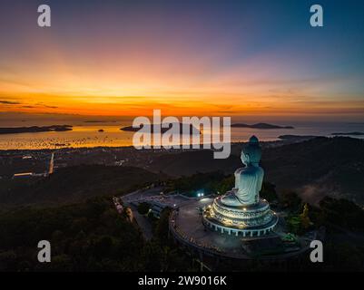 Landschaft aus der Vogelperspektive gelbes Licht am Horizont bei Sonnenaufgang vor Phuket Big Buddha die goldene Sonne scheint durch die Wolken. Die Schönheit der Statu Stockfoto