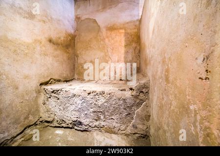 Steinbett im Lupanar, Bordell in der archäologischen Stätte von Pompeji, einer antiken Stadt, die durch den Ausbruch des Vesuv im Jahr 79 n. Chr. zerstört wurde. Stockfoto