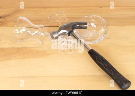 Glasvase mit Hammer auf hölzernem Hintergrund Stockfoto